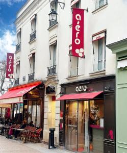 a facade of a building with tables and chairs at Hôtel Aero Paris Passy in Paris