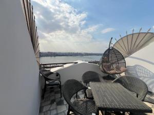 a balcony with chairs and a table and umbrella at كورنيش نيل معادي in Al Ma‘şarah