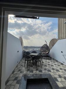 a patio with a table and chairs on a balcony at كورنيش نيل معادي in Al Ma‘şarah