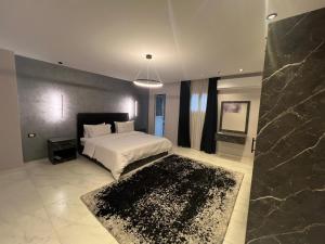 a bedroom with a white bed and a black rug at كورنيش نيل معادي in Al Ma‘şarah