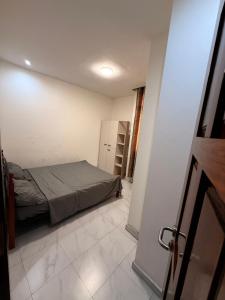 a bedroom with a bed in a white room at Mubi House in Kinshasa