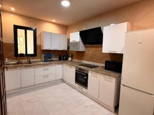 a kitchen with white appliances and white cabinets at Mubi House in Kinshasa