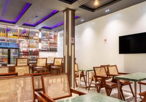 a restaurant with tables and chairs and a tv at Rooks Rest Inn & Apartments in Lagos