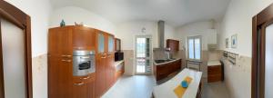 a large kitchen with wooden cabinets and a sink at Cà Turi Sarzana in Sarzana