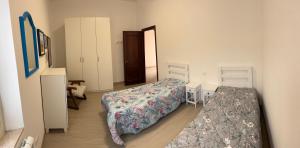 a bedroom with two beds and two chairs in it at Cà Turi Sarzana in Sarzana