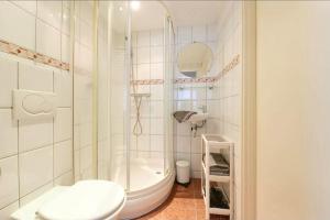 a white bathroom with a shower and a toilet at Blue City Apartment in Alkmaar