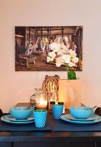 a table with blue bowls and a picture on the wall at Blue City Apartment in Alkmaar
