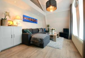 a living room with a couch and a table at Blue City Apartment in Alkmaar