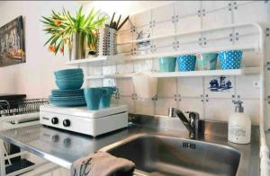 a kitchen with a sink and a counter with dishes at Blue City Apartment in Alkmaar