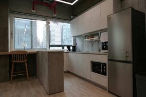 a kitchen with a refrigerator and a chair in it at Stay PLAN B in Seoul