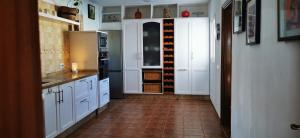 a kitchen with white cabinets and a tile floor at Villa Gozo Holiday house in Teguitar