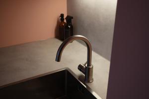 a kitchen sink with a faucet and two bottles at Design Apartment Plön in Plön