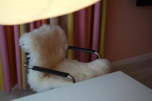 a teddy bear wearing glasses sitting in a chair at Design Apartment Plön in Plön