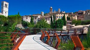 a wooden walkway leading to a city with buildings at Camere Meccoli in Assisi