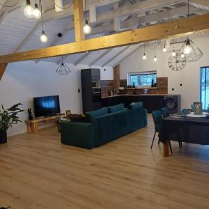 a living room with a green couch and a kitchen at Zacisze Częstkowo in Częstkowo