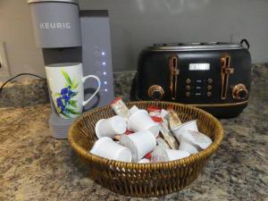 Ein Korb mit Tassen und ein Toaster stehen auf der Theke. in der Unterkunft Chambre privée dans logement partagé in Saint-Nazaire