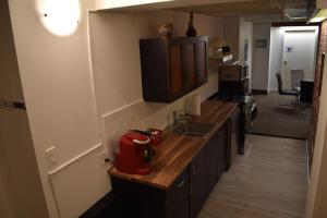 a kitchen with a sink and a red appliance on a counter at Hôtel particulier du marché in Quebec City