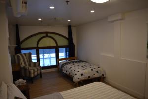 a bedroom with a bed and a chair and a window at Hôtel particulier du marché in Quebec City +13 photos