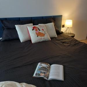 a bed with a book and an open book at Zacisze Częstkowo in Częstkowo +16 photos