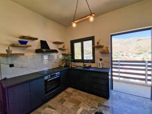 a kitchen with black counters and a large window at family MARIA in Kalymnos