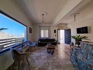 a living room with a couch and a large window at family MARIA in Kalymnos
