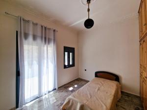 a bedroom with a bed and a large window at family MARIA in Kalymnos