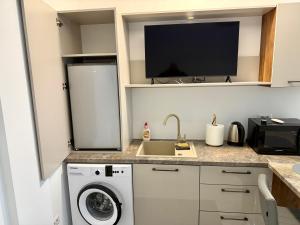 a kitchen with a washing machine and a tv on a counter at visitor's house 4 in Rădăuţi