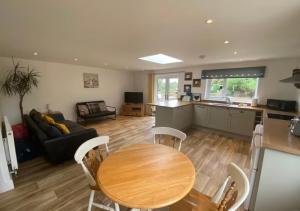 a living room with a wooden table and a kitchen at Mill Lane Holiday Cottage -Bath in Bath