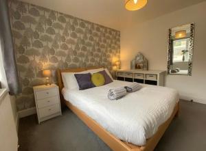 a bedroom with a large bed and a mirror at Mill Lane Holiday Cottage -Bath in Bath