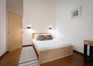 a bedroom with a bed with white sheets and a desk at Harmony Hills Boutique Villa in Ella