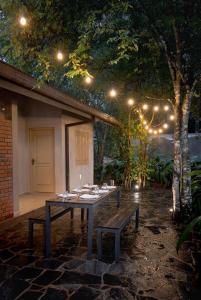 a table and a bench in a courtyard with lights at Harmony Hills Boutique Villa in Ella