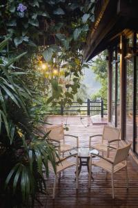 a group of chairs and a table on a porch at Harmony Hills Boutique Villa in Ella