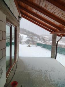 a view from the inside of a building with snow at Căsuța din deal in Tranisu +7 photos