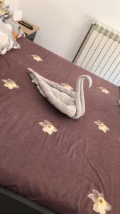 a blanket with a swan on top of a bed at Căsuța din deal in Tranisu