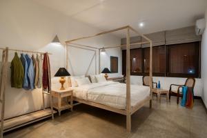 a bedroom with a canopy bed and a table and chairs at Casa18Villa in Kiribathgoda