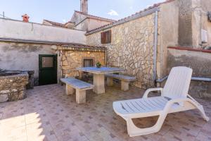 a patio with a table and chairs and a bench at Antique House Orlec in Orlec