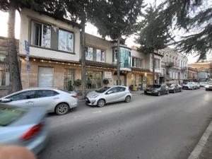 eine Reihe von Autos, die am Straßenrand geparkt sind in der Unterkunft Platformatbilisi in Tbilisi City