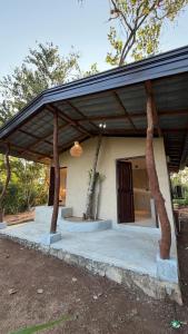 a house with a porch with two trees at Three Tree Villa By Habarana in Habarana