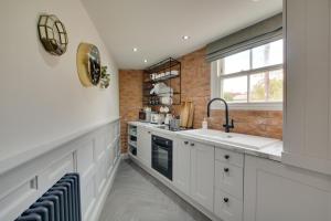 a kitchen with white cabinets and a sink and a window at 1 Bed in Holt oc-1854 in Holt