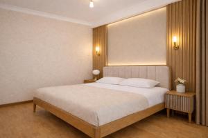a bedroom with a large white bed with two night stands at City Heart Apartment in Tbilisi City