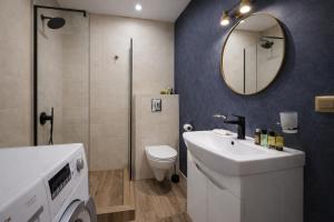 a bathroom with a sink and a toilet and a mirror at City Heart Apartment in Tbilisi City