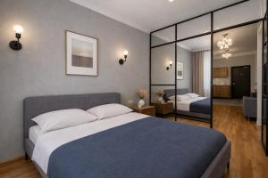 a bedroom with a large bed and a large mirror at City Heart Apartment in Tbilisi City