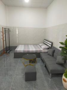 a room with a bed and a couch and a table at Homestay Vườn Dừa in Ấp Nhứt (1)