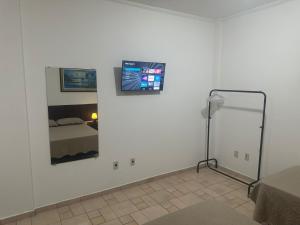 a room with a bed and a tv on a wall at Kitnet no interior de São Paulo 25 in Serra Negra