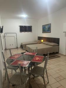 a room with a table and chairs and a bed at Kitnet no interior de São Paulo 25 in Serra Negra
