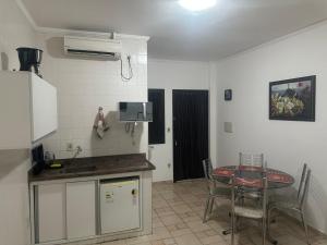 a kitchen with a table and a table and chairs at Kitnet no interior de São Paulo 25 in Serra Negra +3 photos