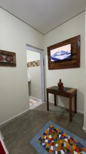 a room with a table and a television on the wall at HOTEL POUSADA MACHADO in Frutal