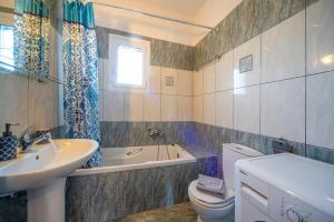 a bathroom with a sink and a toilet and a tub at Villa Amalia By Elayan Villas Corfu in Karousádes +27 photos