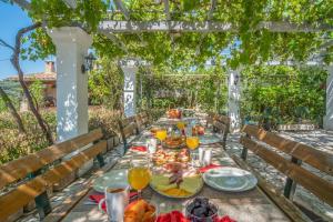 a table set for a meal under a pergola at Villa Amalia By Elayan Villas Corfu in Karousádes