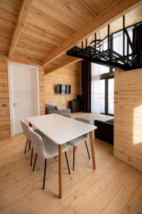 a dining room with a white table and chairs at Gudauri Deka Alpine Cottages in Gudauri